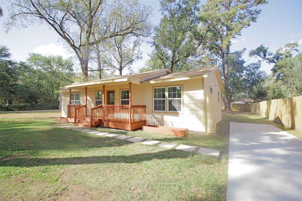 single story home featuring a deck and a front yard