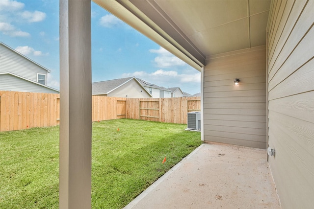 view of yard with central AC and a patio