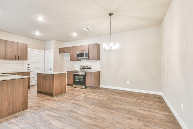 kitchen with a kitchen island, decorative light fixtures, backsplash, a notable chandelier, and stainless steel appliances