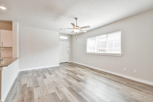 unfurnished living room featuring light hardwood / wood-style floors and ceiling fan