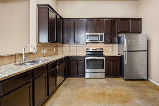 kitchen with sink, light stone counters, dark brown cabinets, stainless steel appliances, and decorative backsplash