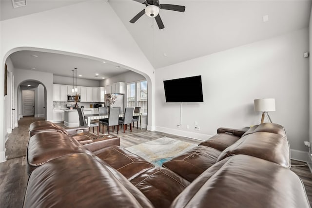 living room with ceiling fan, dark hardwood / wood-style floors, and high vaulted ceiling