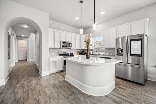 kitchen with appliances with stainless steel finishes, a center island, and white cabinets