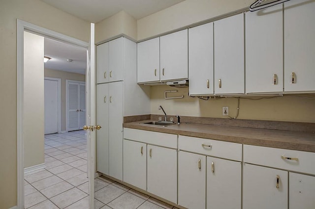 kitchen with white cabinetry, sink, and light tile patterned floors