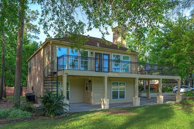 back of property featuring a deck, a patio area, and a lawn