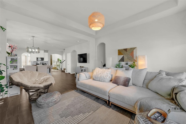 living room featuring dark wood-type flooring and a chandelier