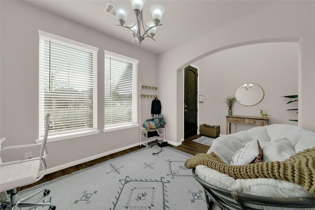 7 Calistoga Cir, Manvel, TX 77578 - living area featuring a chandelier, arched walkways, wood finished floors, and baseboards