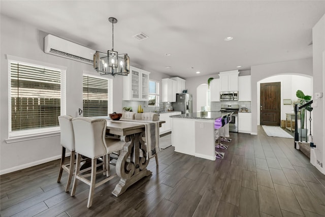 dining space featuring a notable chandelier and an AC wall unit