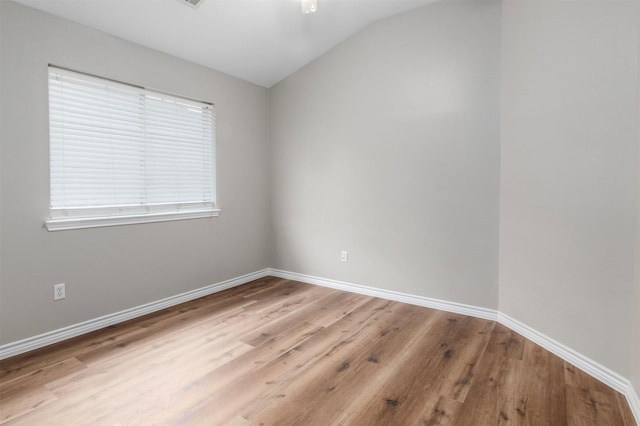 empty room featuring lofted ceiling and light hardwood / wood-style floors