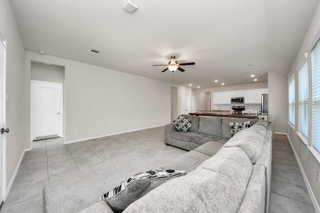 tiled living room with ceiling fan