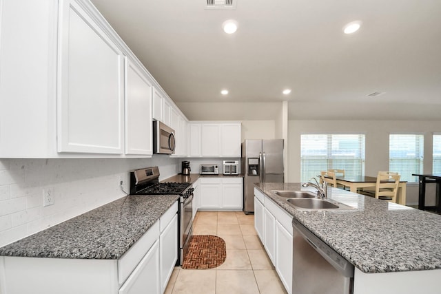 kitchen featuring sink, stainless steel appliances, an island with sink, white cabinets, and light tile patterned flooring