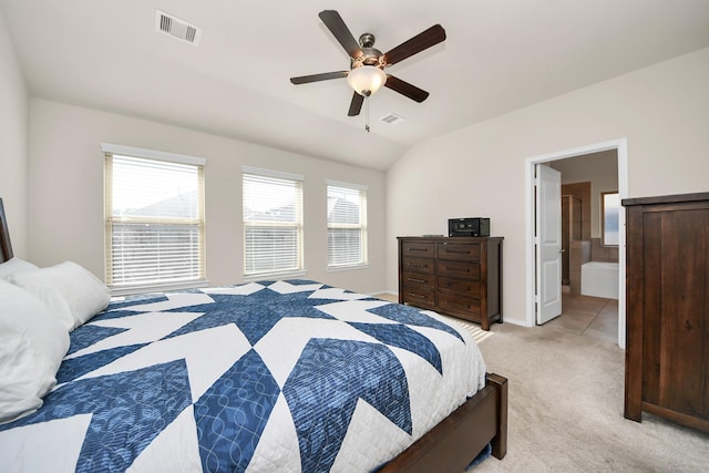 bedroom with ceiling fan, ensuite bath, lofted ceiling, and light carpet