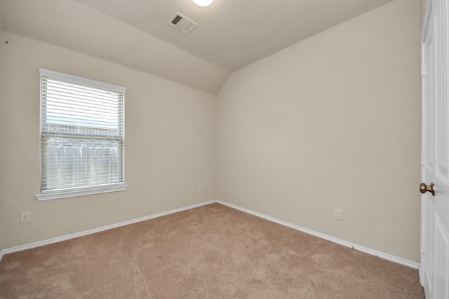 carpeted empty room with lofted ceiling