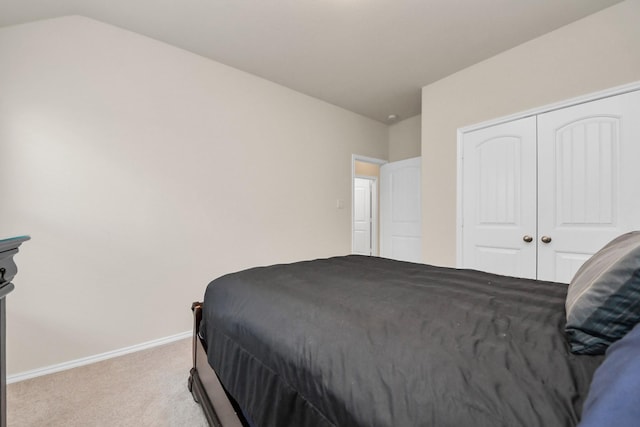 carpeted bedroom with vaulted ceiling and a closet