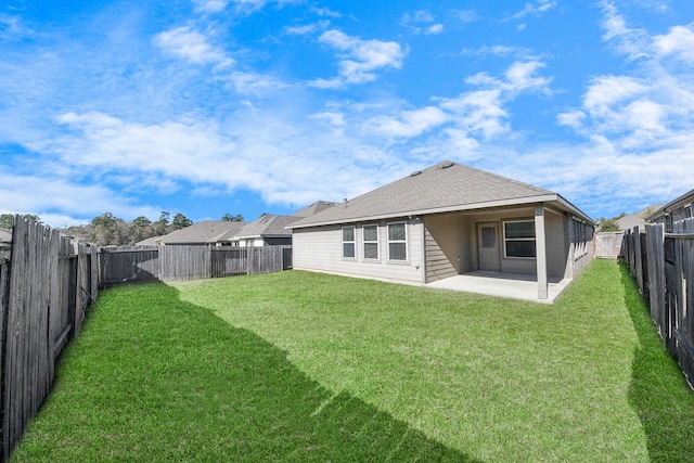 rear view of property featuring a yard and a patio area