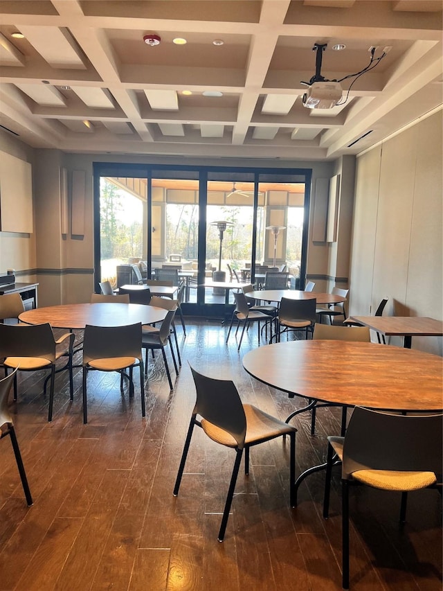 dining space featuring coffered ceiling, dark wood-type flooring, ceiling fan, and beam ceiling