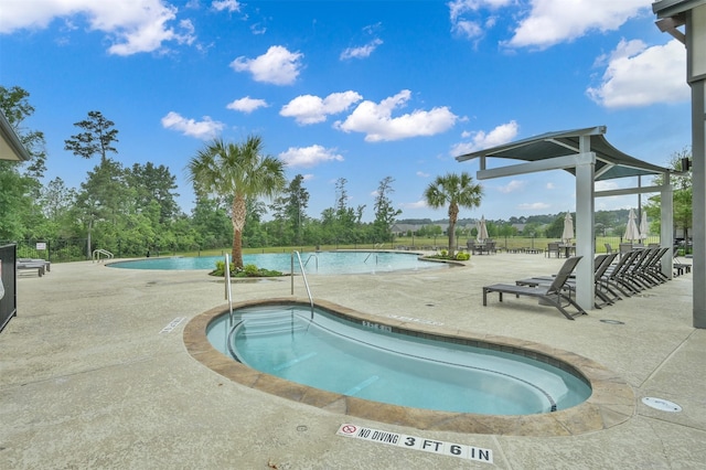 view of swimming pool with a hot tub and a patio