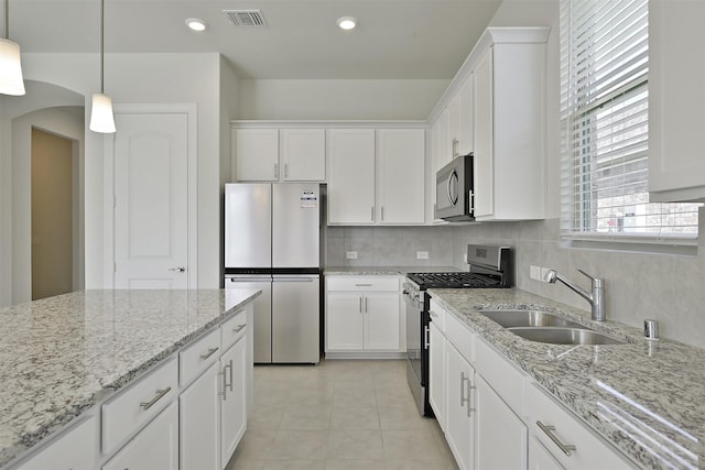 kitchen with sink, decorative light fixtures, white cabinets, and appliances with stainless steel finishes