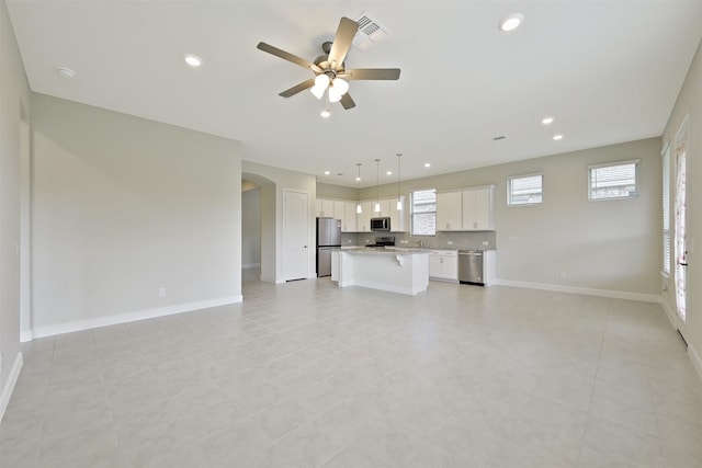 unfurnished living room with light tile patterned floors, sink, and ceiling fan