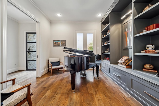 misc room with hardwood / wood-style floors, crown molding, and built in shelves