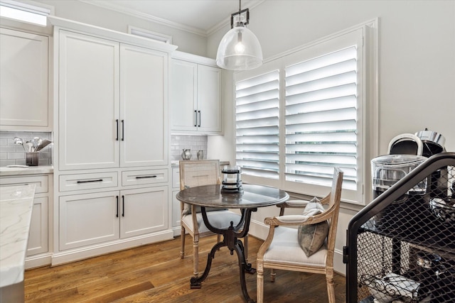 dining area featuring ornamental molding and light hardwood / wood-style flooring