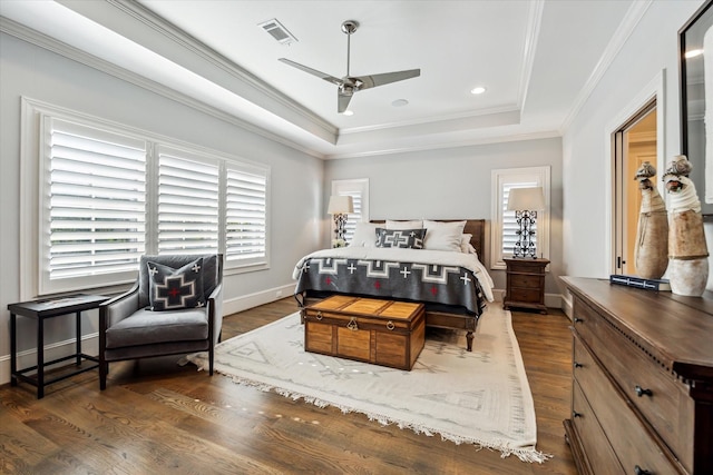 bedroom with a raised ceiling, ornamental molding, dark hardwood / wood-style floors, and ceiling fan