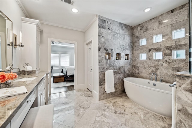 bathroom with ornamental molding, a washtub, vanity, and tile walls