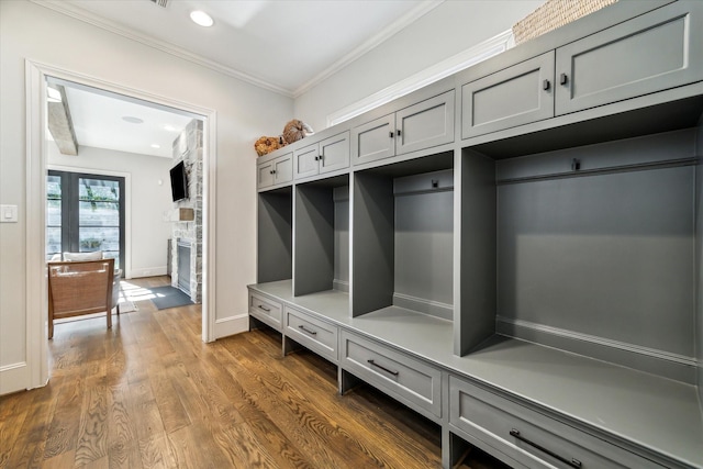 mudroom with crown molding, dark hardwood / wood-style floors, and a fireplace