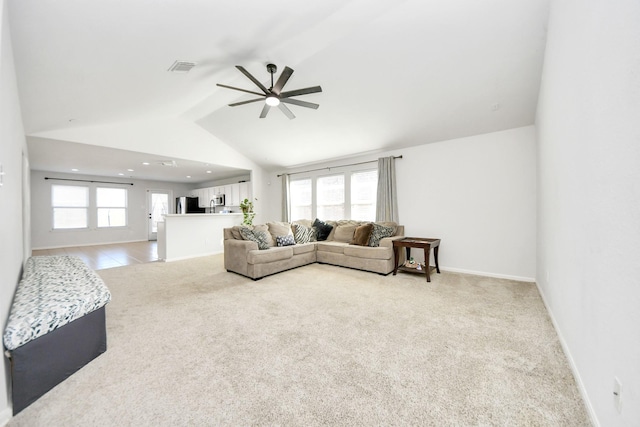 living room with ceiling fan, high vaulted ceiling, and light carpet