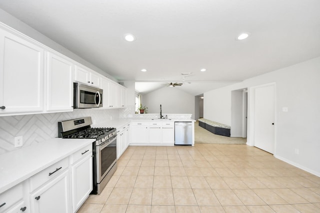 kitchen featuring vaulted ceiling, appliances with stainless steel finishes, tasteful backsplash, white cabinets, and ceiling fan