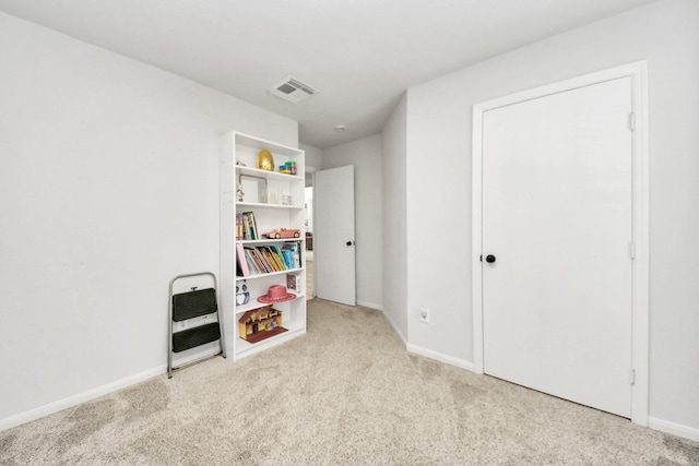 recreation room with light carpet and heating unit