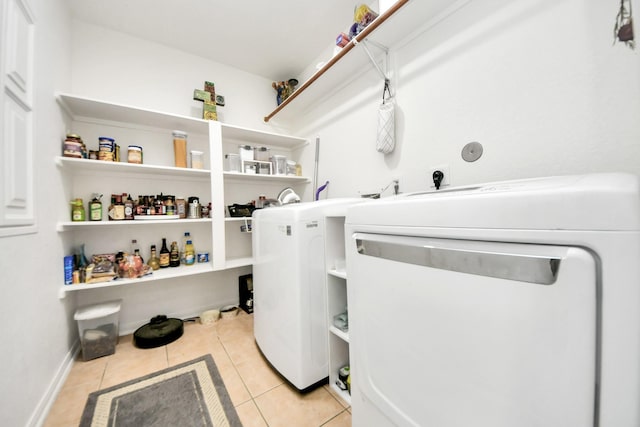 laundry area with light tile patterned floors and washing machine and clothes dryer