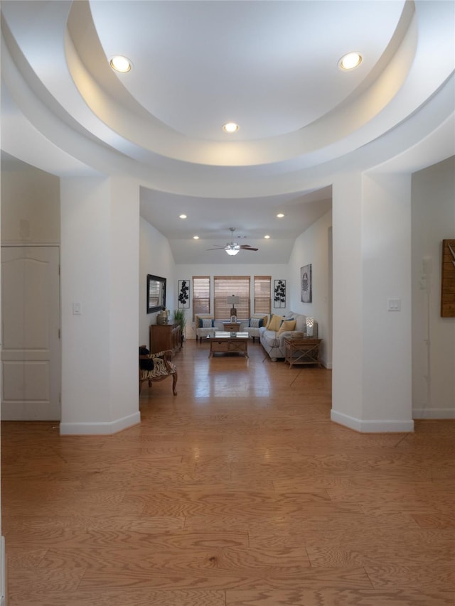 hall with light hardwood / wood-style flooring and a tray ceiling