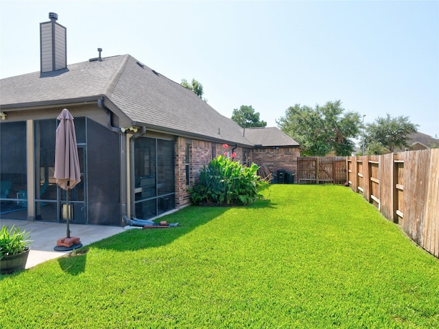 view of yard with a sunroom and a patio area