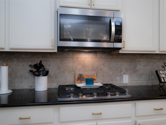 kitchen featuring white cabinetry, appliances with stainless steel finishes, and decorative backsplash