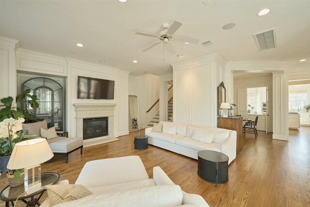 kitchen featuring a kitchen island, a breakfast bar area, white cabinets, built in appliances, and light stone counters