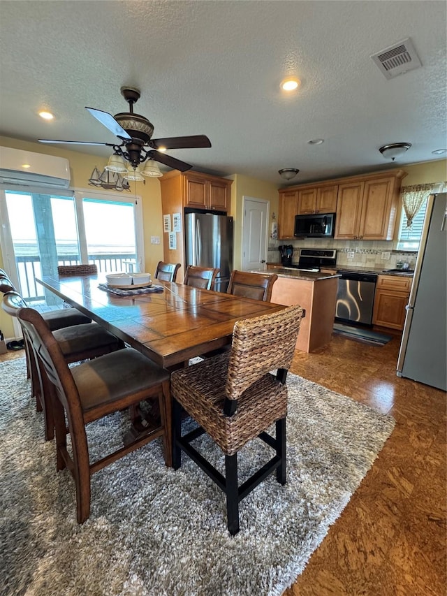 dining space with a wall mounted air conditioner, a textured ceiling, and ceiling fan