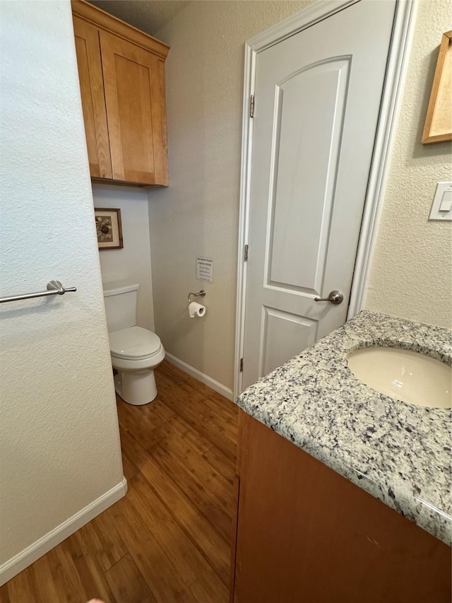 bathroom featuring vanity, toilet, and hardwood / wood-style floors