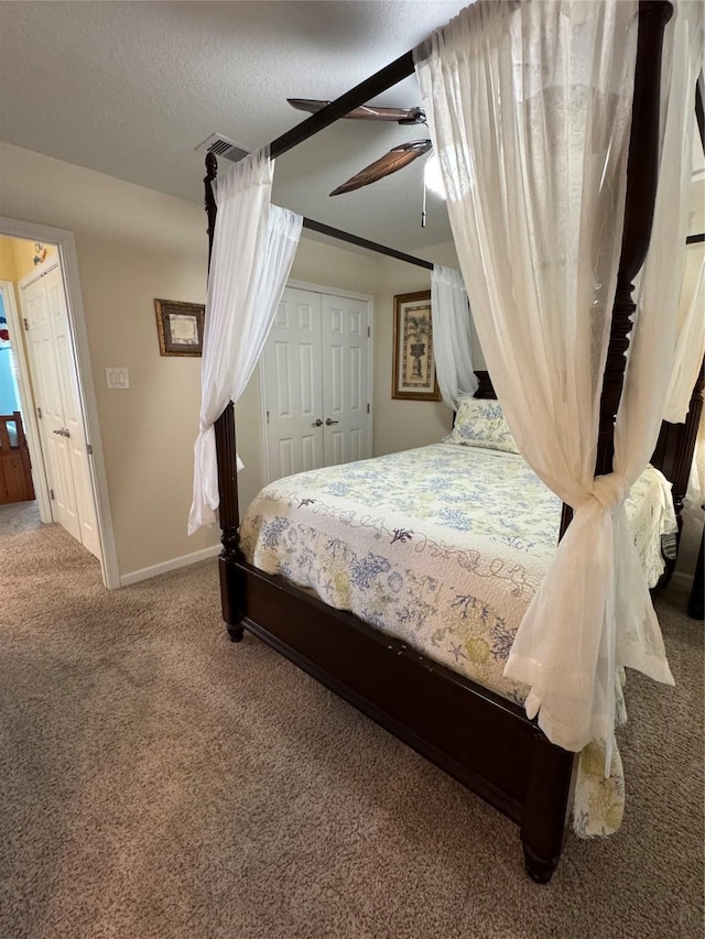 bedroom featuring ceiling fan, a closet, carpet, and a textured ceiling