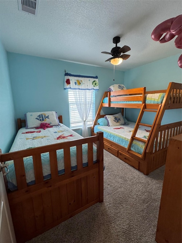 carpeted bedroom featuring a textured ceiling and ceiling fan