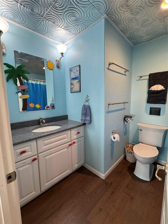 bathroom with wood-type flooring, toilet, and vanity