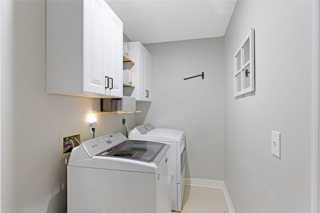 clothes washing area with cabinets, separate washer and dryer, and light tile patterned floors