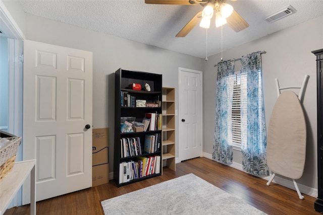 misc room featuring ceiling fan, dark hardwood / wood-style floors, and a textured ceiling