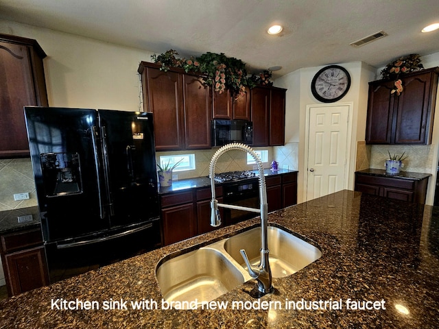 kitchen featuring sink, dark stone countertops, backsplash, dark brown cabinets, and black appliances