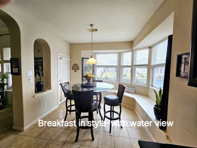 tiled dining room with a textured ceiling