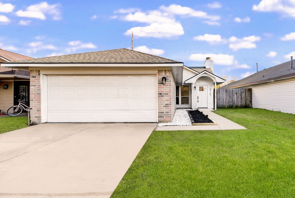 view of front of home with a garage and a front yard