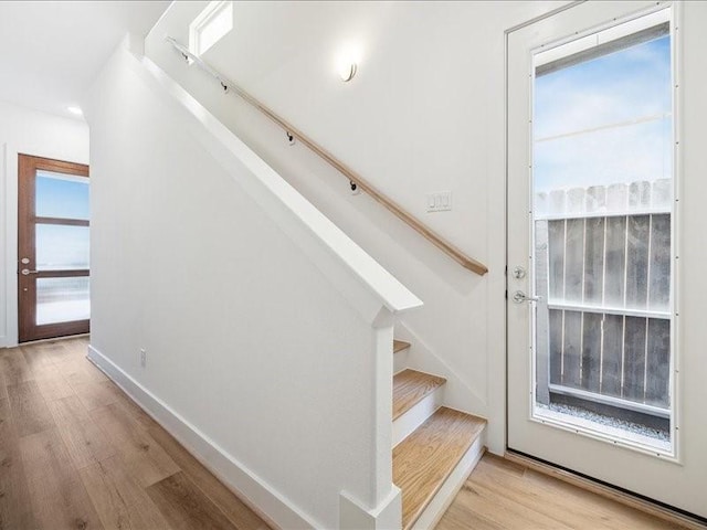 stairway with hardwood / wood-style floors and a healthy amount of sunlight