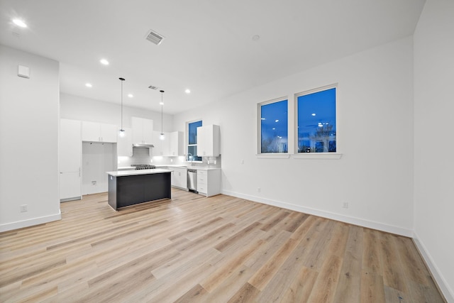 kitchen featuring white cabinetry, decorative light fixtures, a center island, light wood-type flooring, and dishwasher