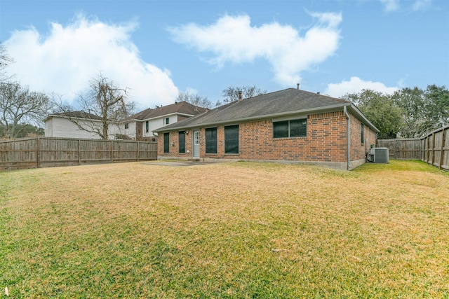 rear view of house with a yard and central air condition unit