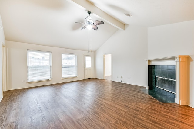 unfurnished living room featuring a tiled fireplace, hardwood / wood-style flooring, lofted ceiling with beams, and ceiling fan